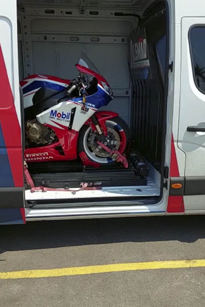 Race motorcycle inside the back of a van on a ramp