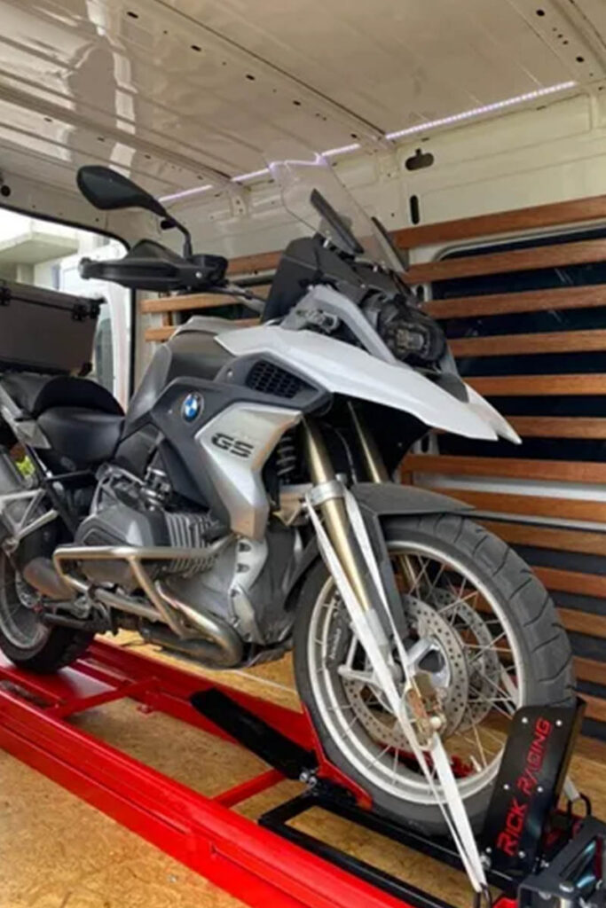 Motorcycle on a red ramp inside a van